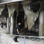 A Kuala Lumpur police officer inspects the damage to the Metro Tabernacle Church which was destroyed by a fire bomb in the Kuala Lumpur suburb of Desa Melawati,08 Jan 2010 (Photo AP)