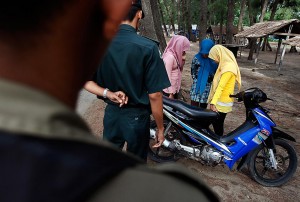 LA Times: "The Sharia police stop three veiled teenage girls at a beach in Banda Aceh, Indonesia, a city where Islamic religious codes of public behavior are strictly enforced. The girls' crime: wearing tights. They were told to go home immediately and change into proper attire."