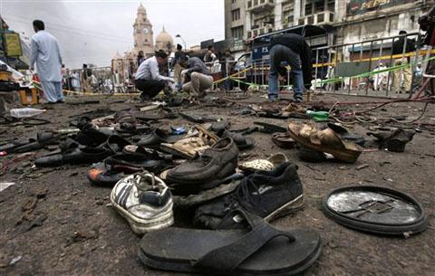 Pakistani investigators collect evidence from the site of Monday's suicide bombing in Karachi, 29 Dec 2009 (Photo AP)