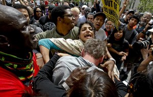 "A woman tries to protect a man (with head down) who was being attacked by counter-demonstrators outside L.A. City Hall." (Photo: Anne Cusack / Los Angeles Times / April 17, 2010) 
