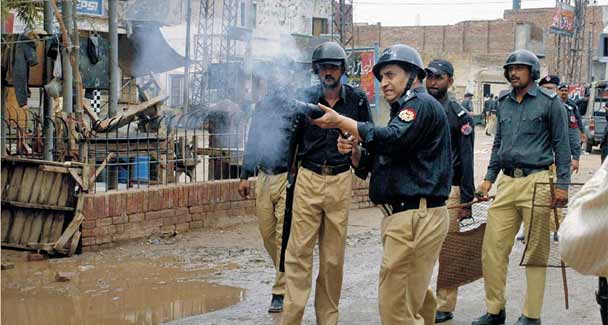Policemen fire teargas shells to disperse the protesters during a demonstration against the killing of two Christian brothers outside the court building in Faisalabad. –Online Photo 