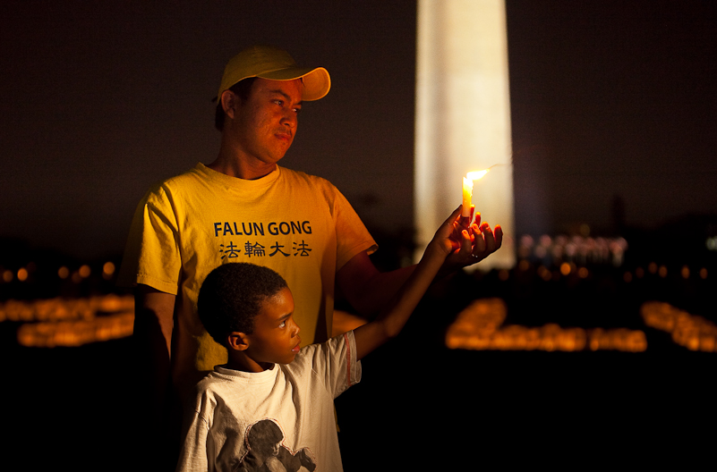 Two Falun Dafa practitioners hold a candle at the candle light vigil in Washington, DC on July 22nd -- marking 11 years of persecution in China. (Jeff Nenarella / The Epoch Times) 